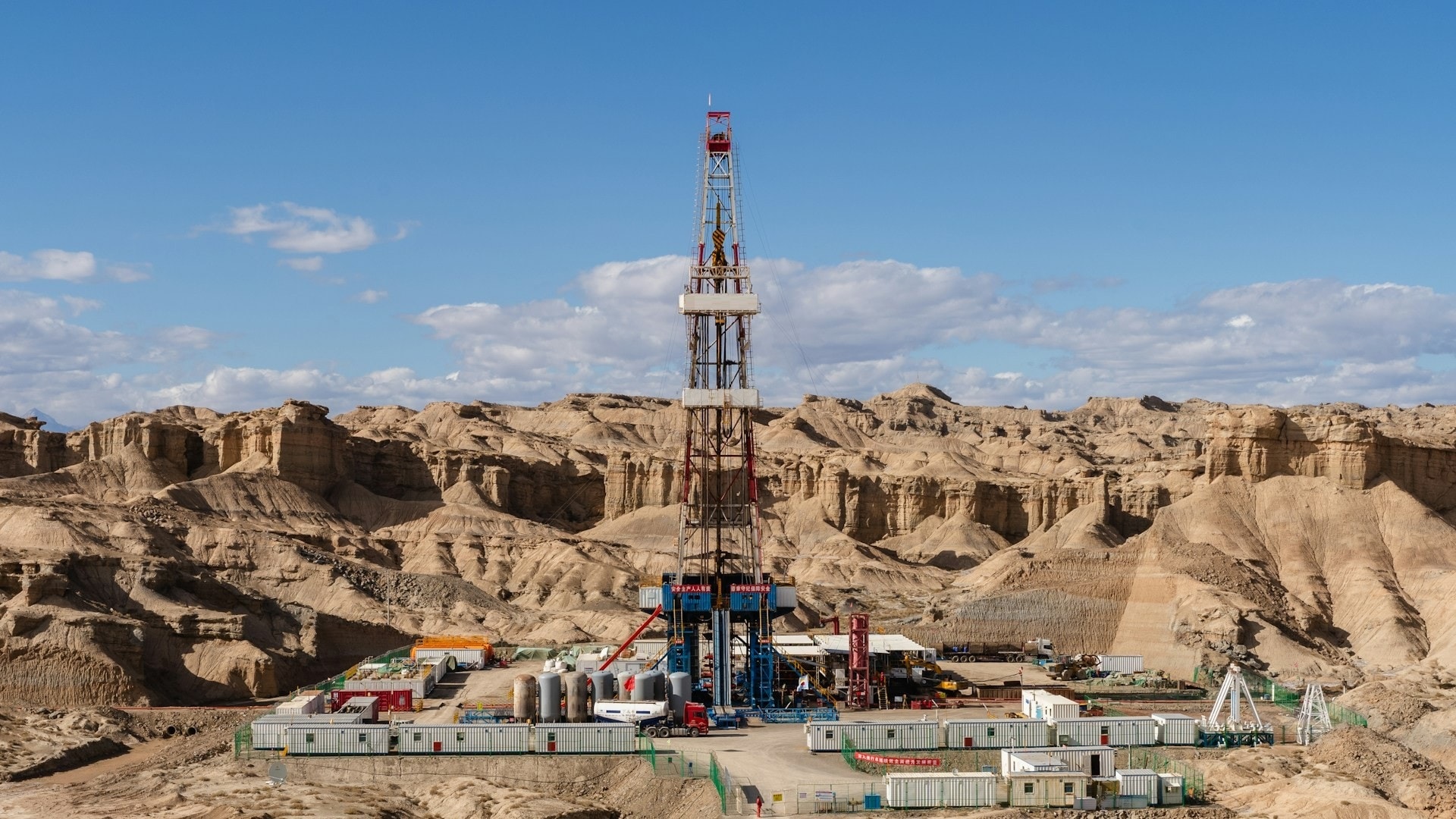 Onshore drilling rig in a desert canyon under blue sky